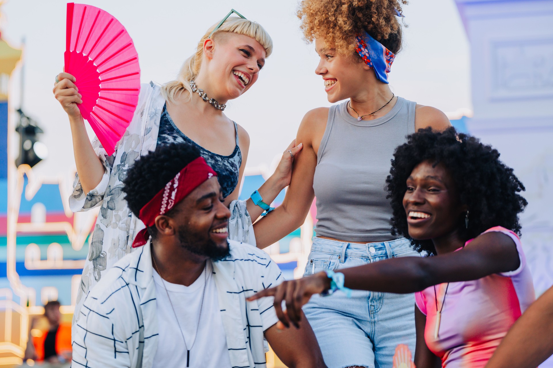 Young friends laughing and having fun together at music festival