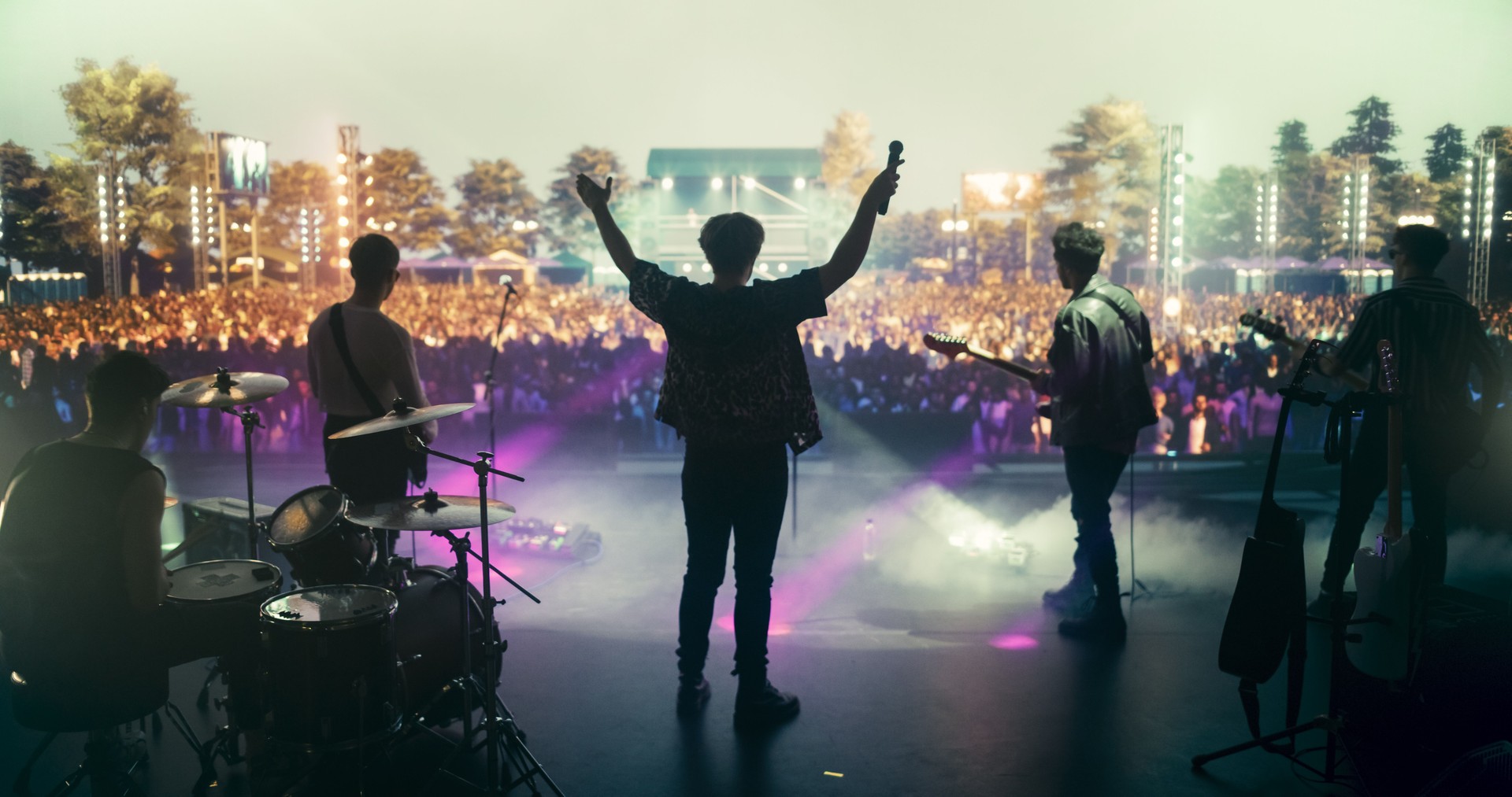 Rock Musicians in Fashionable Outfits Performing Alternative or Punk Rock Music on Festival Stage, Passionately Playing Guitars Under Bright Spotlights, Bringing Energy to Cheering Fans
